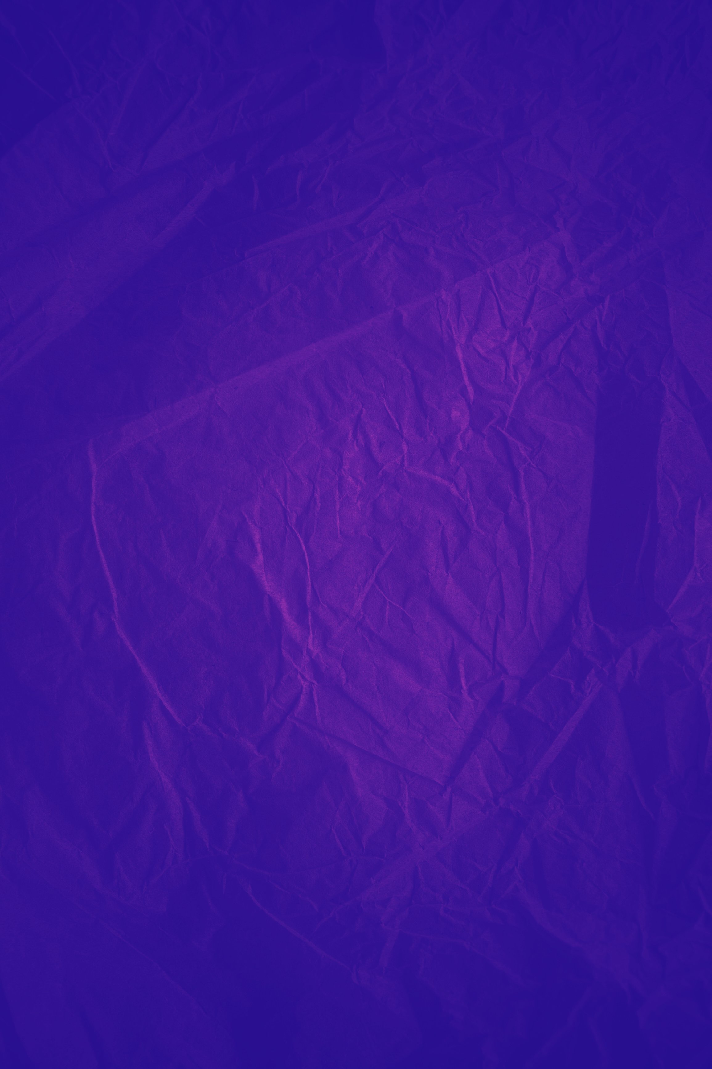 Rough purple vintage paper. Purple crumpled paper texture and background in vintage style. Macro view of wrinkled purple texture made with paper. Purple abstract texture and background for designers.