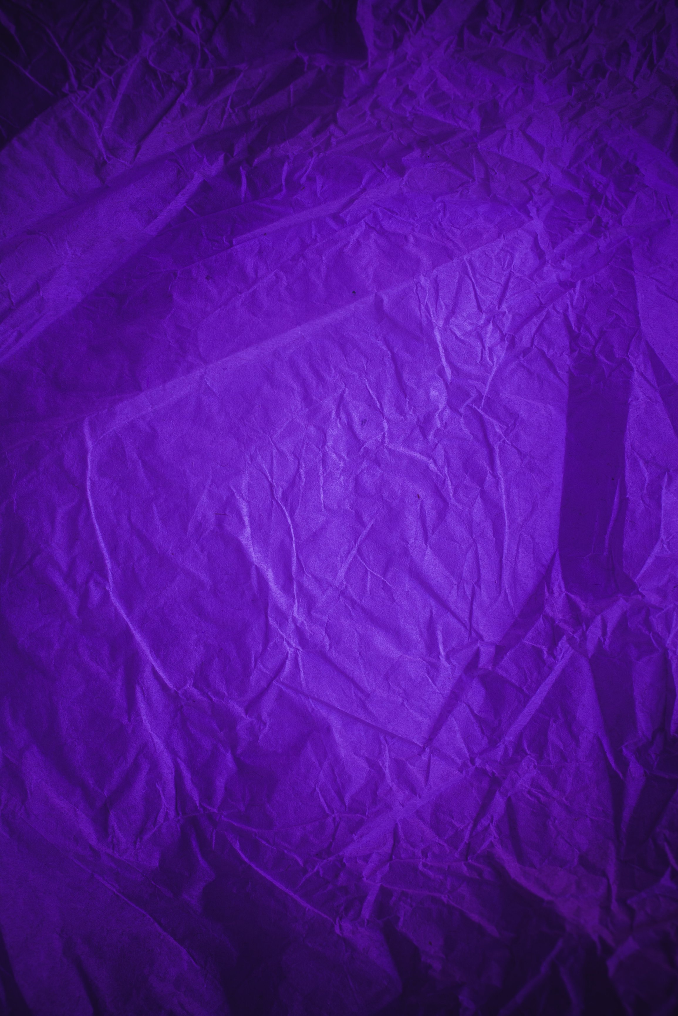 Rough purple vintage paper. Purple crumpled paper texture and background in vintage style. Macro view of wrinkled purple texture made with paper. Purple abstract texture and background for designers.